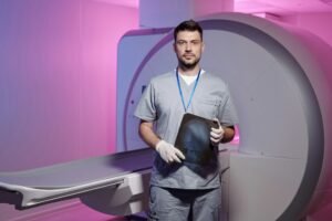 Young successful radiologist with x-ray image standing by workplace